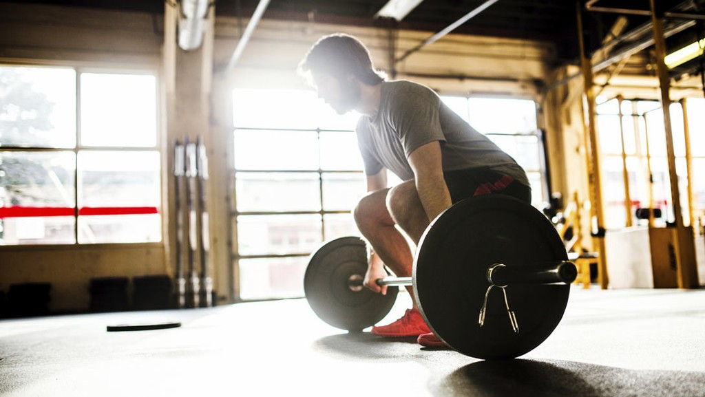 man-performing-deadlift-in-garage.jpg